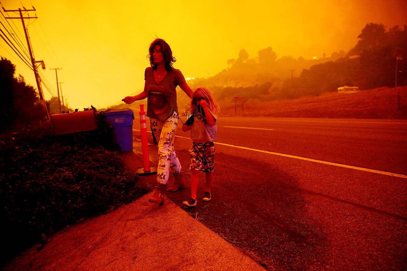 Una mujer y su hija huyen del incendio de Woolsey en Malibu, California.