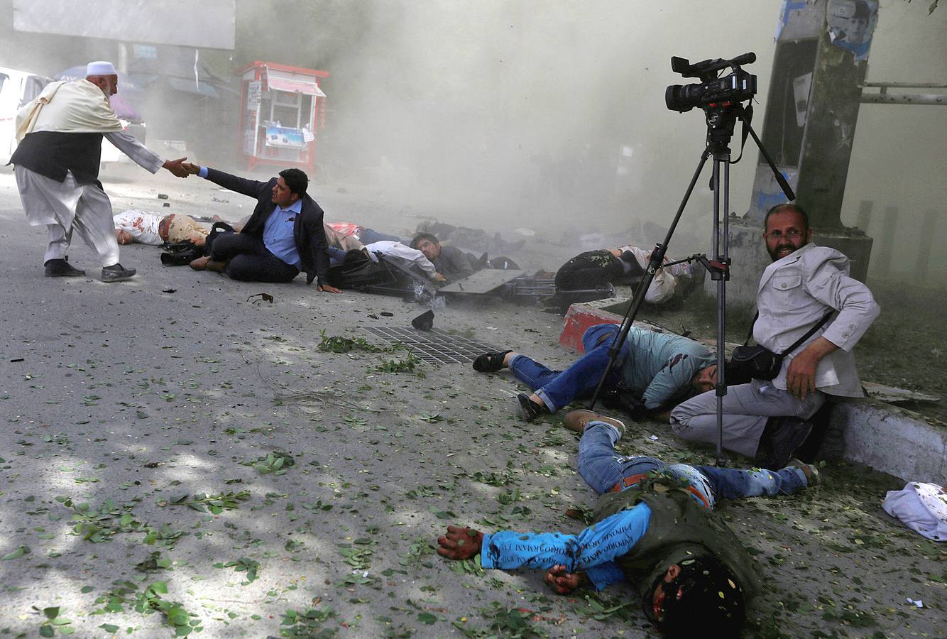 Periodistas afganos y civiles, después de una segunda explosión en Kabul, Afganistán.