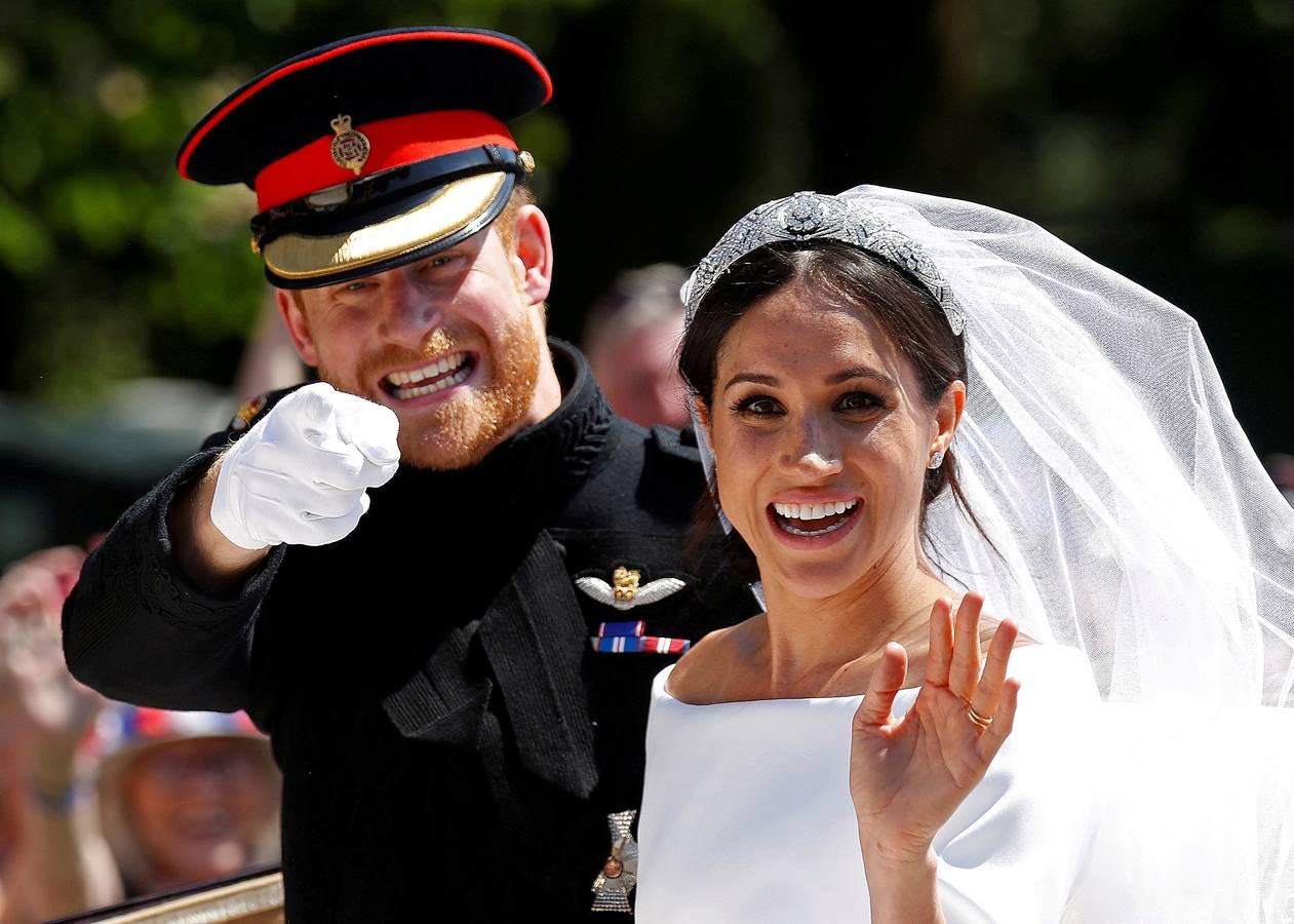 El Príncipe Harry hace un gesto junto a su esposa Meghan Markle mientras viajan en un carruaje tirado por caballos después de su ceremonia de boda en la Capilla de San Jorge en el Castillo de Windsor en Windsor, Gran Bretaña.