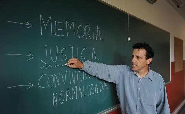 Iñaki García Arrizabalaga, hijo de Juan Manuel García Cordero, asesinado por los Comandos Autónomos Anticapitalistas, subrayando la palabra justicia en una pizarra. 