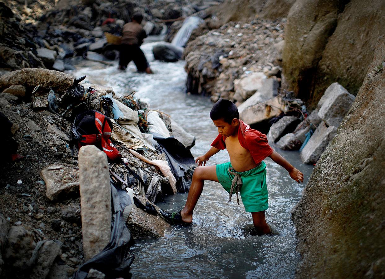 'La Mina', en la ciudad de Guatemala, se encuentra al fondo de un barranco atravesado por un río. Centenares de personas se afanan cada día entre sus aguas contaminadas, bajo la amenaza de deslizamientos y enfermedades, para tratar de encontrar objetos o chatarra con la que ganarse la vida. Algunos utilizan imanes para atraparlos, otros lo hacen a mano, introduciendo su cuerpo directamente en el agua, convertida en basurero. Si hay suerte pueden conseguir unos 20 dólares, el doble del salario mínimo. En ocasiones hasta es posible hallar un anillo o un pendiente de oro.