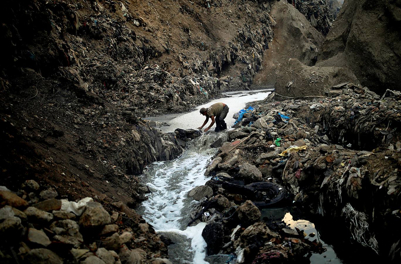 'La Mina', en la ciudad de Guatemala, se encuentra al fondo de un barranco atravesado por un río. Centenares de personas se afanan cada día entre sus aguas contaminadas, bajo la amenaza de deslizamientos y enfermedades, para tratar de encontrar objetos o chatarra con la que ganarse la vida. Algunos utilizan imanes para atraparlos, otros lo hacen a mano, introduciendo su cuerpo directamente en el agua, convertida en basurero. Si hay suerte pueden conseguir unos 20 dólares, el doble del salario mínimo. En ocasiones hasta es posible hallar un anillo o un pendiente de oro.