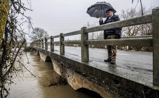 Un hombre observa la crecida del río Zadorra.