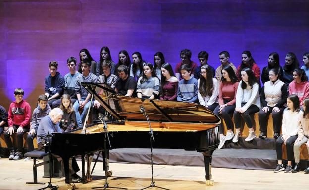 Achúcarro tocando ante la treintena de niños atentos. 