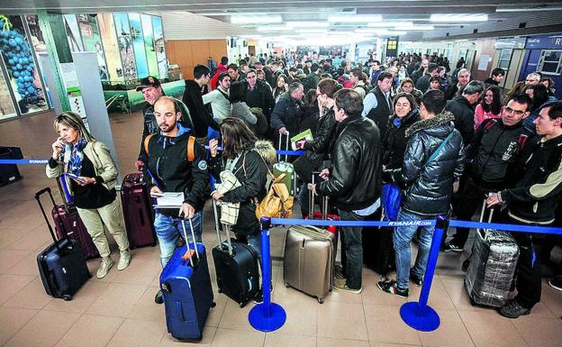 Pasajeros aguardan con sus equipajes en el aeropuerto vitoriano.