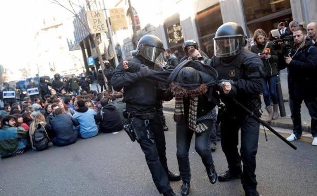 Efectivos de los Mossos d'Esquadra desalojan a una de las personas que se han concentrado ante la Fiscalía de Barcelona.