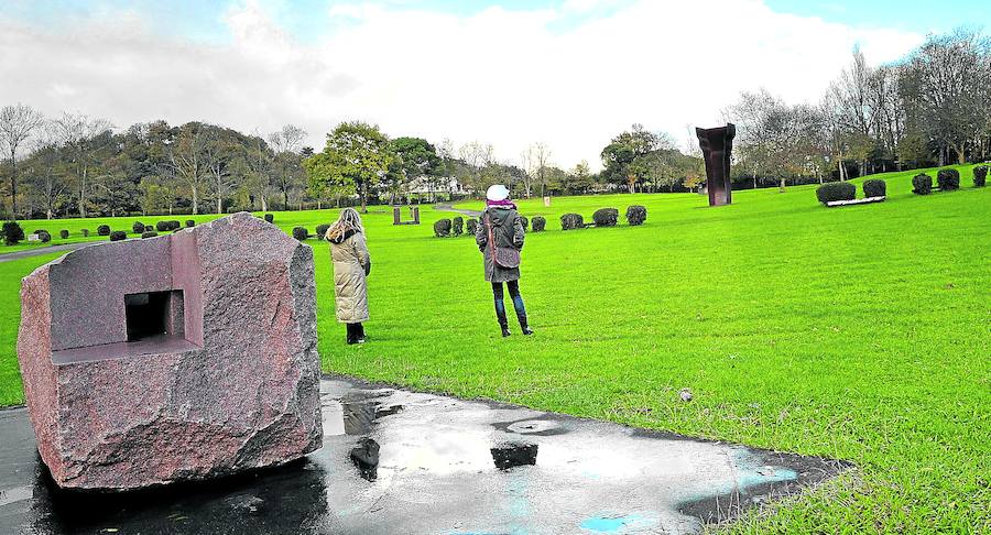 Dos mujeres observan varias esculturas de Chillida en la campa que rodea el caserío de Zabalaga.