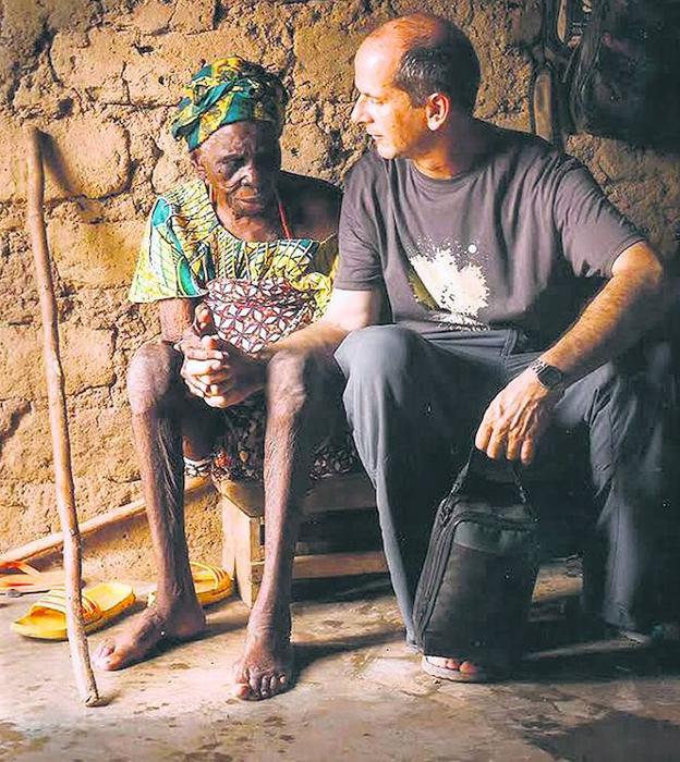 El misionero riojano Juan Pablo López acompaña a una anciana de Benín. 