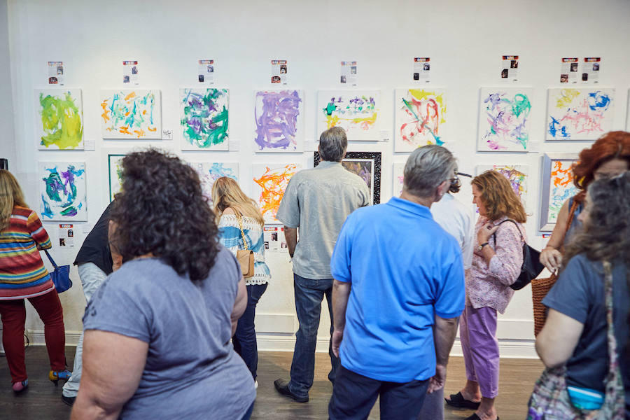 Un grupo de personas ven una exposición de pinturas hechas por simios en Florida (EE UU)