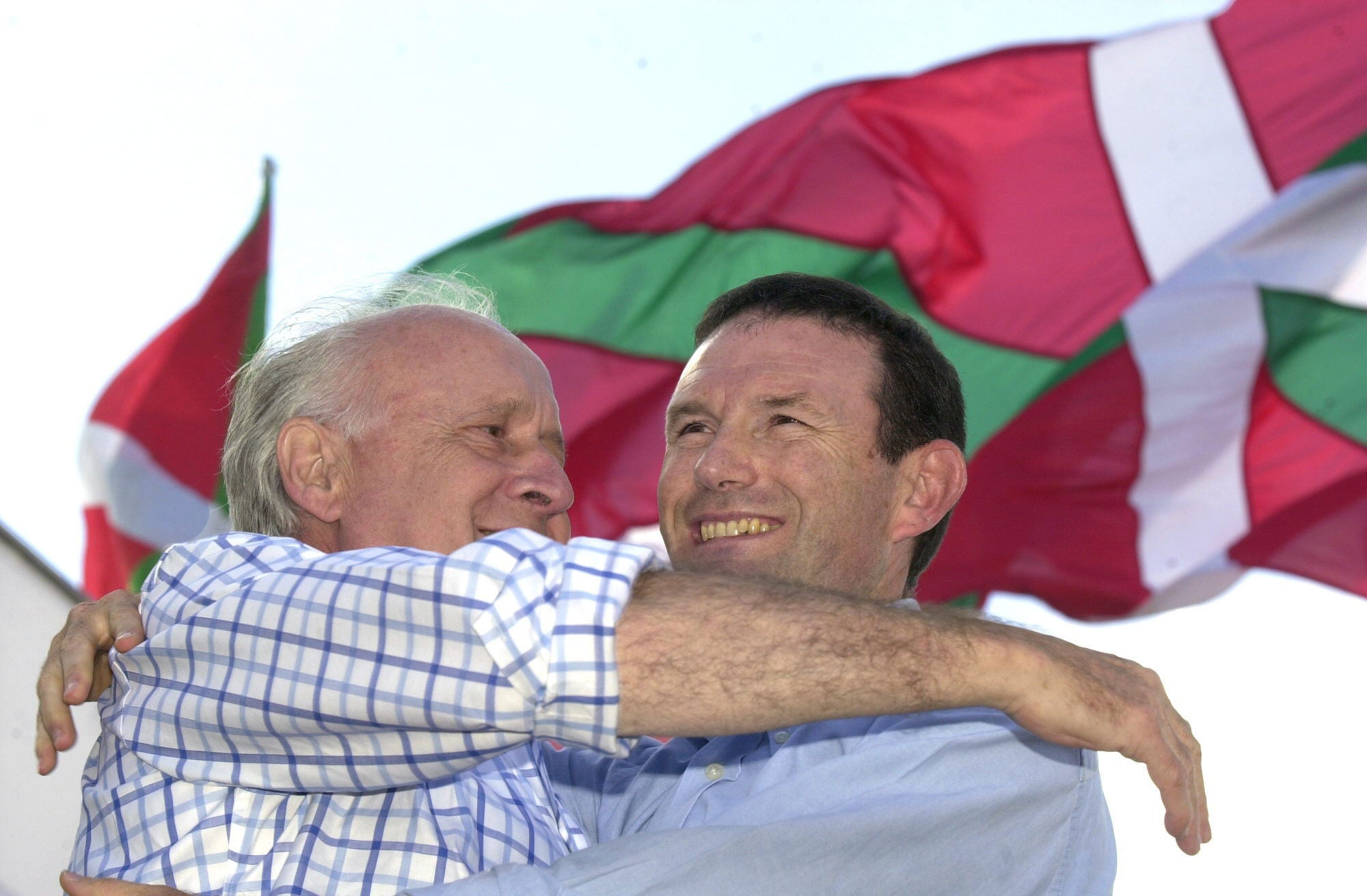 Xabier Arzalluz (i), presidente del EBB, y Juan José Ibarretxe, lehendakari, se abrazan durante el mitin organizado por el PNV, en Foronda (Álava), con motivo de la celebración del Alderdi Eguna en 2003.