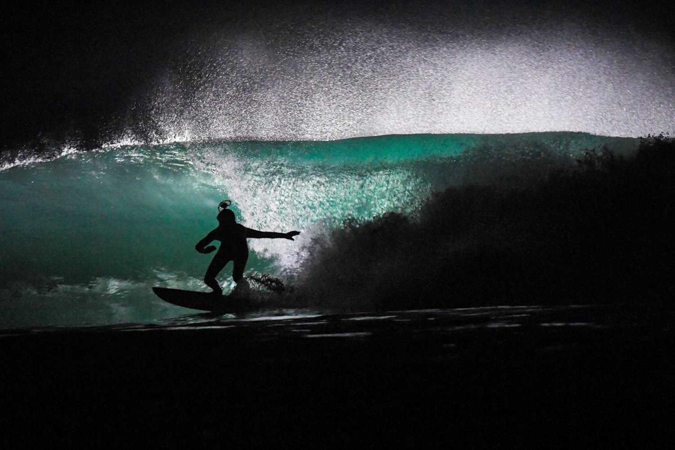 Los surfistas Yann Le Her, Alan, Yohann, Robin y Damien desafían el frío y la oscuridad en una sesión de surf nocturno en la playa del Cabo Fréhel, Bretaña