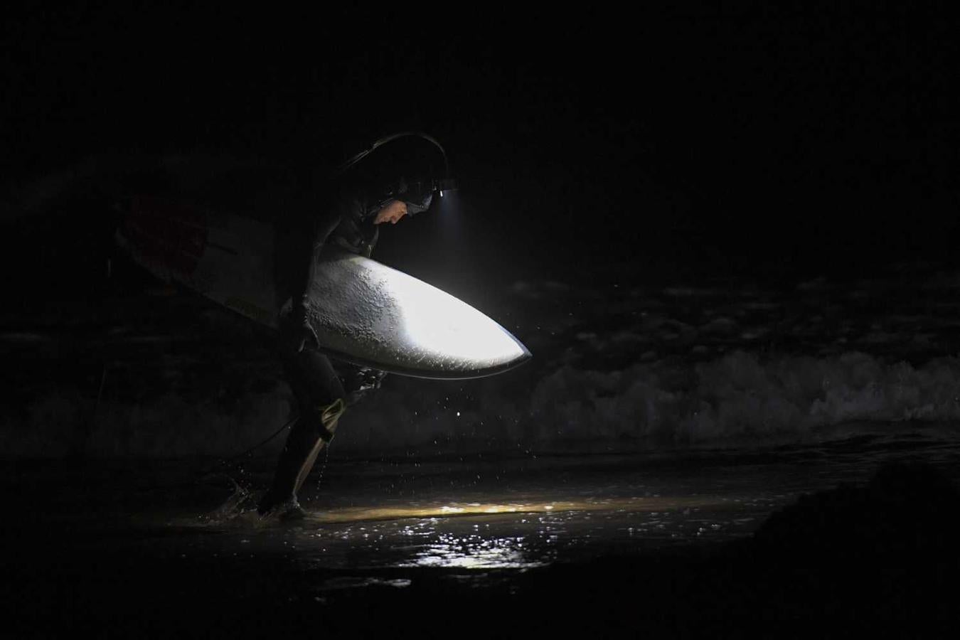 Los surfistas Yann Le Her, Alan, Yohann, Robin y Damien desafían el frío y la oscuridad en una sesión de surf nocturno en la playa del Cabo Fréhel, Bretaña