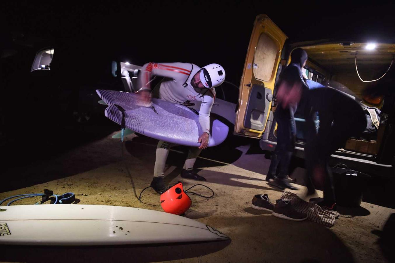 Los surfistas Yann Le Her, Alan, Yohann, Robin y Damien desafían el frío y la oscuridad en una sesión de surf nocturno en la playa del Cabo Fréhel, Bretaña