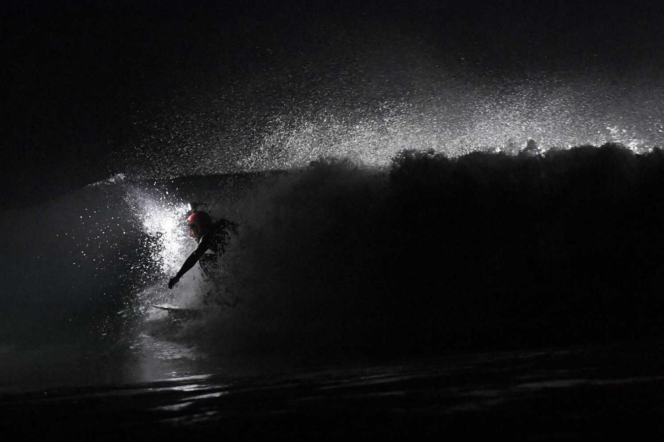 Los surfistas Yann Le Her, Alan, Yohann, Robin y Damien desafían el frío y la oscuridad en una sesión de surf nocturno en la playa del Cabo Fréhel, Bretaña