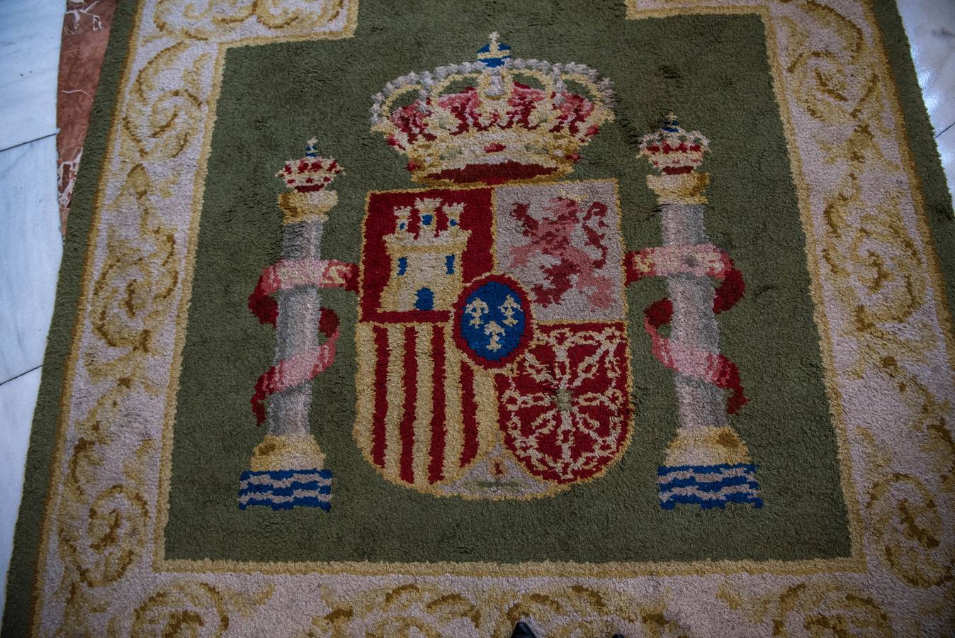 Escudo de España en la alfombra que decora la escalera principal.