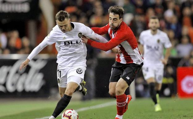 Beñat lucha por un balón con un jugador del Valencia.