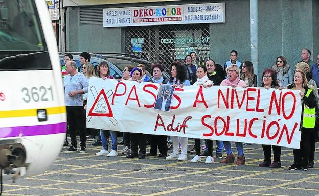 Un tren cruza por delante de los manifestantes, que ayer debieron atravesar hasta cinco pasos a nivel en su recorrido.