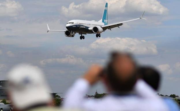 Un grupo de personas observan el vuelo de un Boeing 737 MAX 8, como el que se estrelló el domingo en Etiopía.