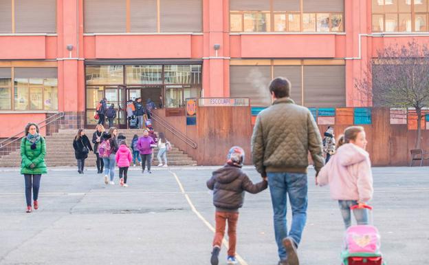 Un padre acude con sus hijos al colegio.