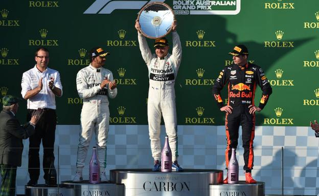 Bottas muestra el trofeo de ganador en el podio de Melbourne entre Hamilton y Verstappen. 