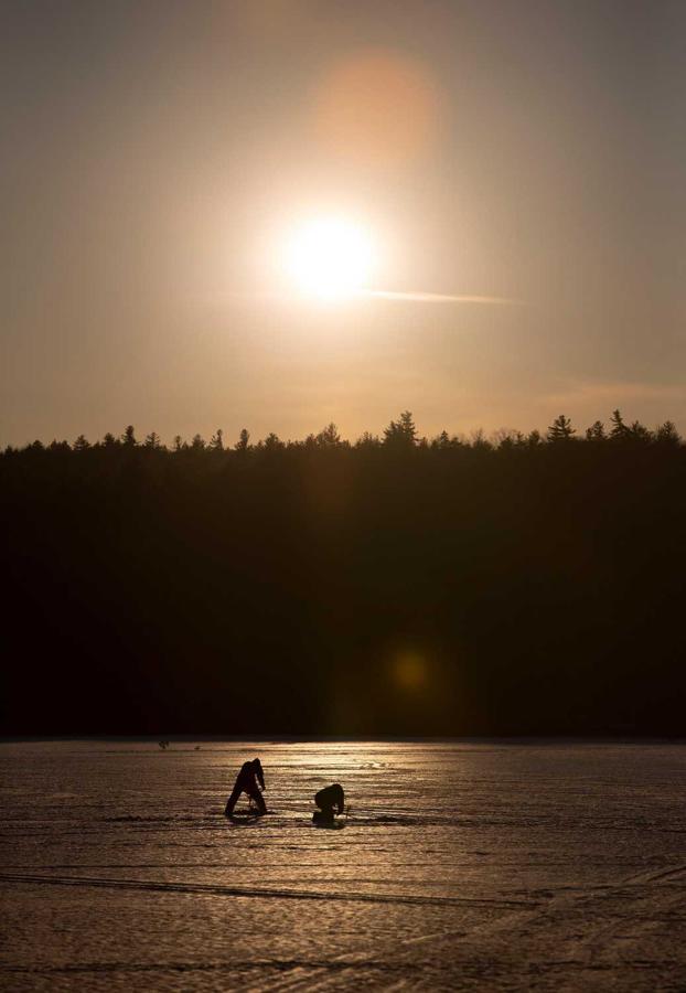 Dos personas pescan durante la puesta de sol en el lago Chocorua, en Tamworth, New Hampshire, EEUU