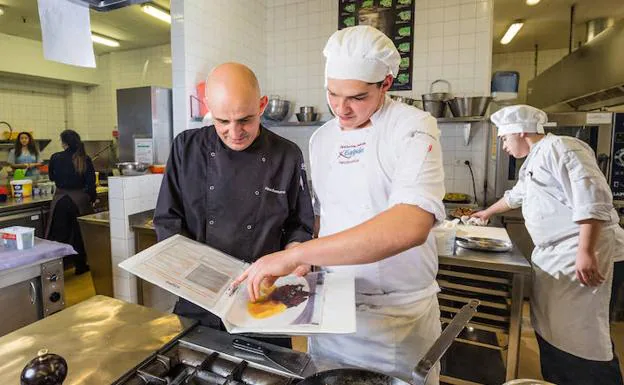 Aitor Basterra repasa la ficha técnica de un plato junto a uno de sus discípulos. 