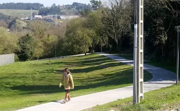 Una mujer camina por uno de los renovados caminos de Aiboa. 