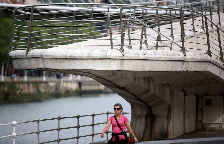 Una mujer pasea junto al puente Zubizuri.