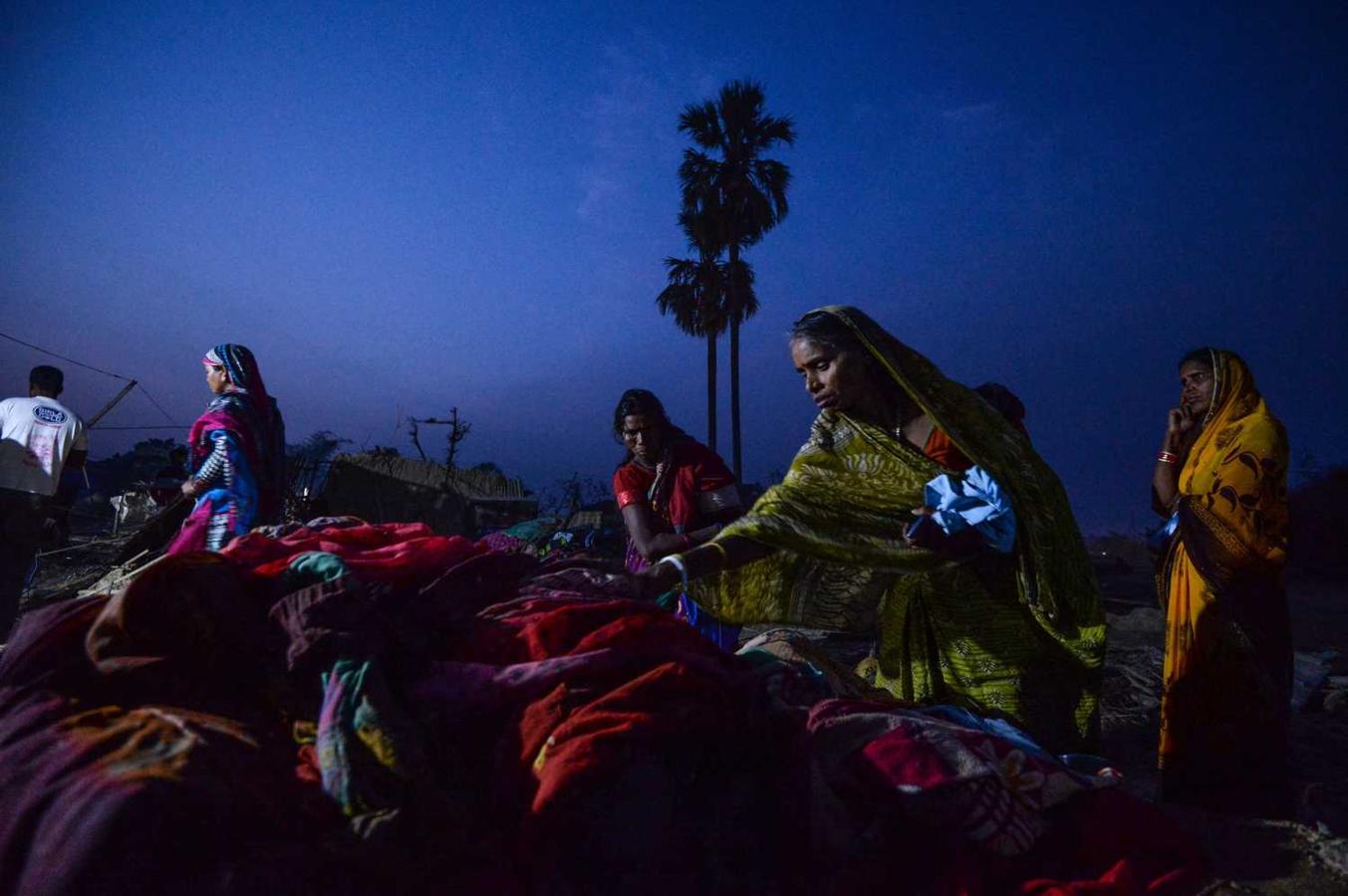 Mujeres nepalíes buscando sus pertenencias entre los restos de las casas dañadas por una imprevista tormenta de primavera en Bhaluhi Bharbaliya. La fuerte tormenta ha causado la muerte de al menos 27 personas.