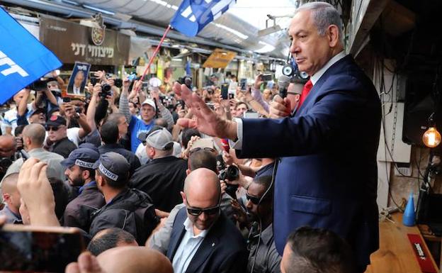 El primer ministro israelí y presidente del partido Likud, Benjamin Netanyahu, se dirige a simpatizantes mientras recorre el mercado Mahane Yehuda. 