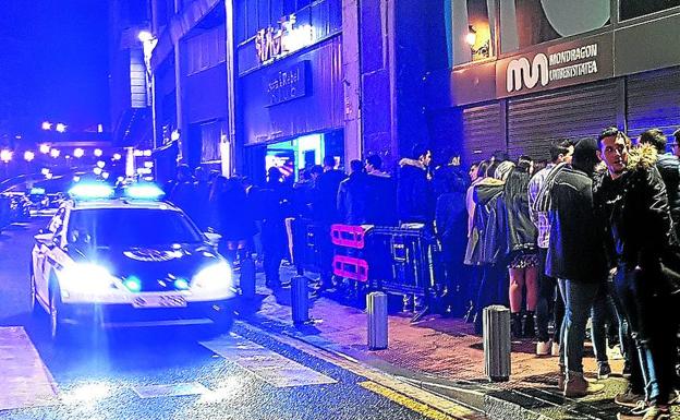 Imagen principal - En la primera imagen, Colas en la entrada a una discoteca de moda en Uribitarte. Hasta siete patrullas vigilaban la zona el pasado fin de semana. En la segunda, detención en Bilbao. Y en la tercera, Dos ertzainas cubren un incidente en un local de hostelería del Casco Viejo bilbaíno en el turno de noche, la madrugada del sábado al domingo pasados. 