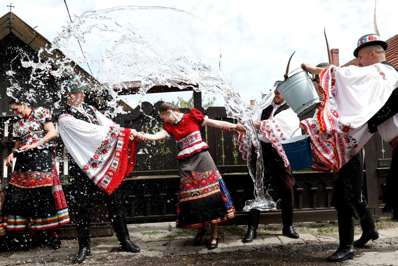 Hombres lanzando agua sobre mujeres durante una celebración tradicional de Semana Santa en Mezokovesd, Hungría 