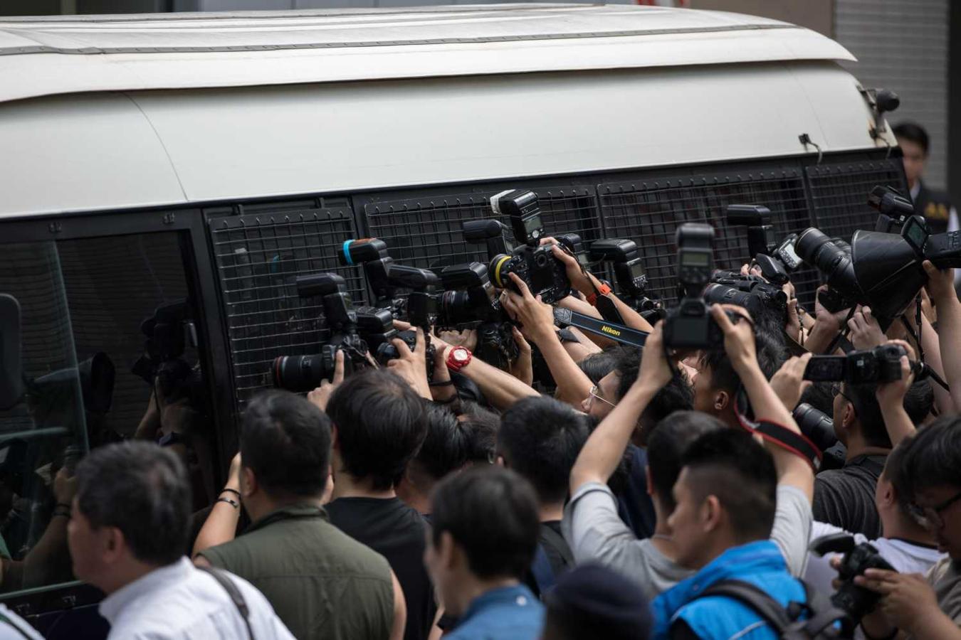 Un vehículo policial traslada a los activistas de la "Revolución de los Paraguas"desde el Tribunal de Kowloon Oeste en Hong Kong (China). Destacados activistas de la "Revolución de los Paraguas", que movilizó a miles de personas en 2014 para exigir avances democráticos en Hong Kong, fueron condenados hoy con penas de hasta 16 meses de prisión por cargos como incitación, conspiración y alteración del orden público. 