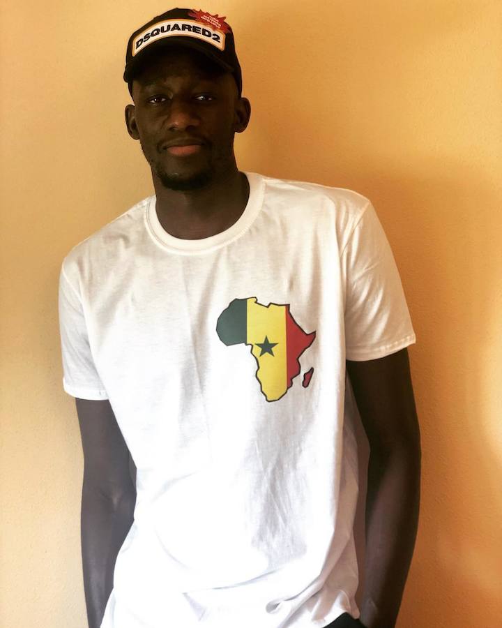 Diop con gorra de Dsquared2 y una camiseta con la silueta del continente africano y la bandera de su país natal, Senegal.