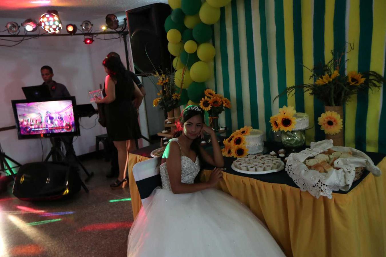 Arianny Itriago se sienta durante su quinceañera (15 cumpleaños) en el vecindario de Catia en Caracas, Venezuela. El padre de Arianny, Ronny, dijo: "Es una tradición familiar celebrar una quinceañera. Ahora todo es muy caro en nuestro país. Todo se maneja con base en el dólar estadounidense, nuestros bolívares no tienen mucho peso debido a la inflación, estamos prácticamente dolarizados ... La música que contratamos fue de 80 o 90 dólares estadounidenses ".