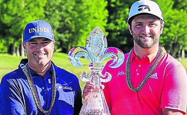 Jon Rahm y Ryan Palmer posan con el trofeo y los cinturones de ganadores del Zurich Classic. 