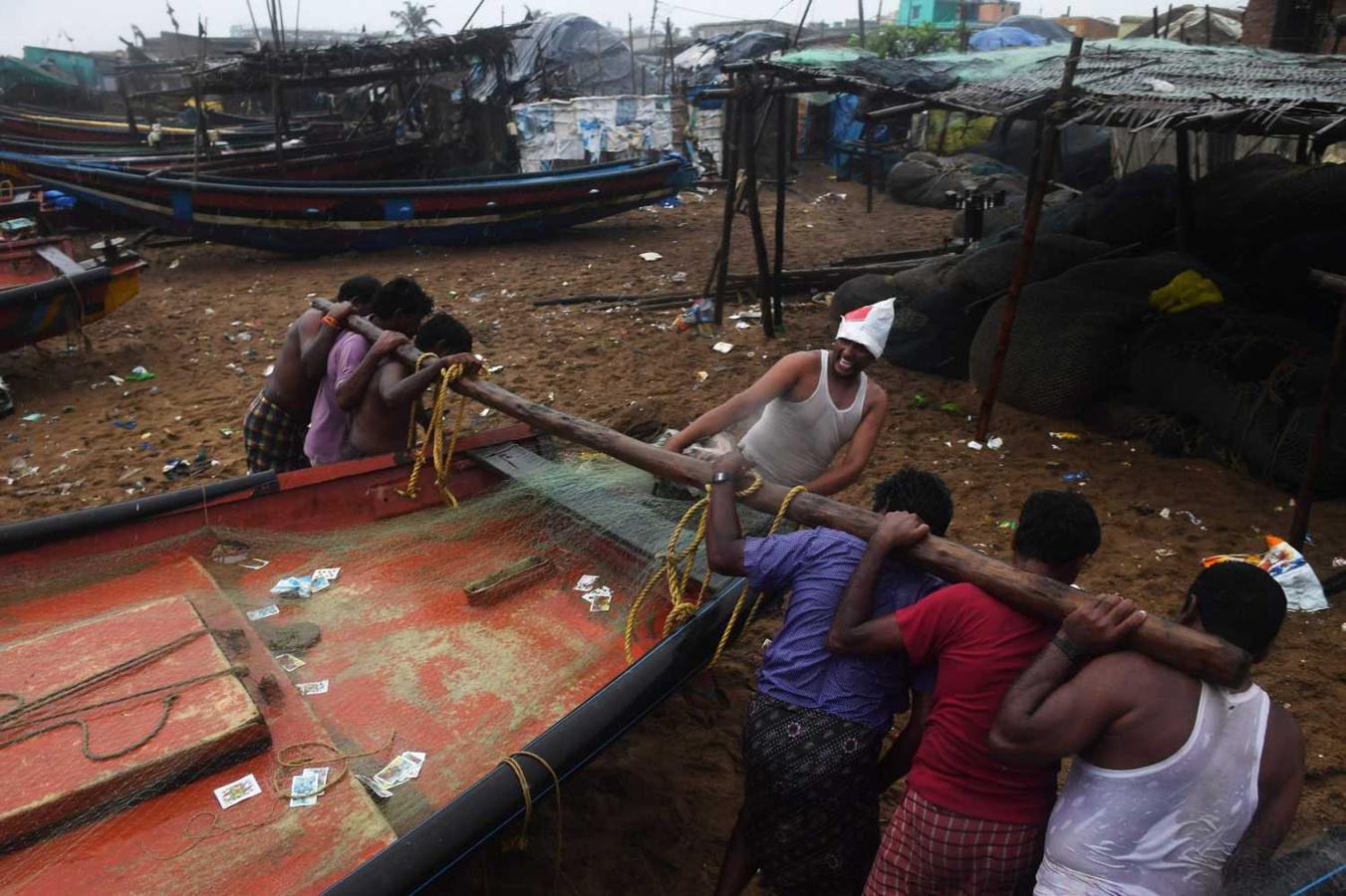 Pescadores indios sacan un bote a un terreno más alto en la playa de Puri, en el estado de Odisha, tras anunciarse la llegada del ciclón Fani