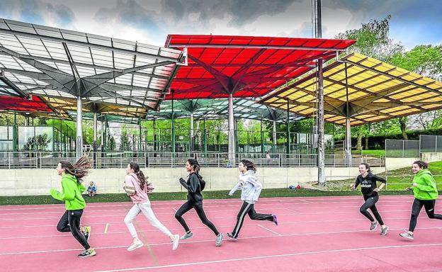 Unas atletas corren ante las canchas de pádel, debajo de las cuales y en paralelo a la pista actual está previsto el módulo.