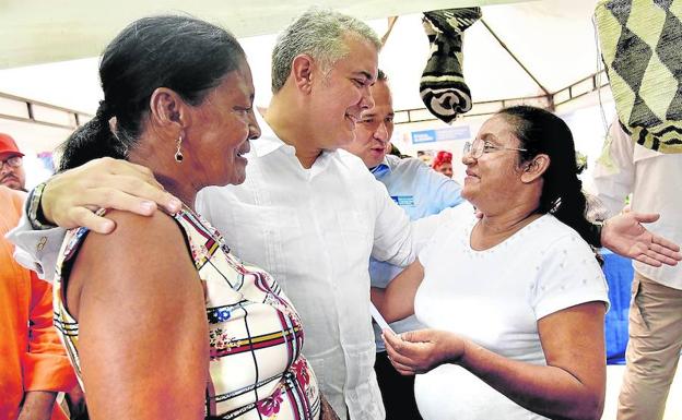 El presidente colombiano, Iván Duque, conversa con dos mujeres durante un acto en la ciudad de Valledupar.