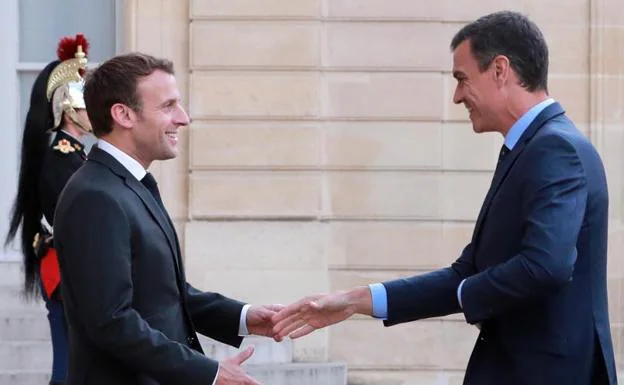 El presidente del Gobierno en funciones, Pedro Sánchez (d), es recibido por el presidente francés, Emmanuel Macron (c-i), antes de una reunión este lunes en el Palacio del Elíseo en París