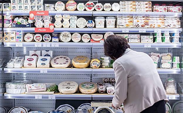 Una mujer compra queso en un supermercado de Alemania.
