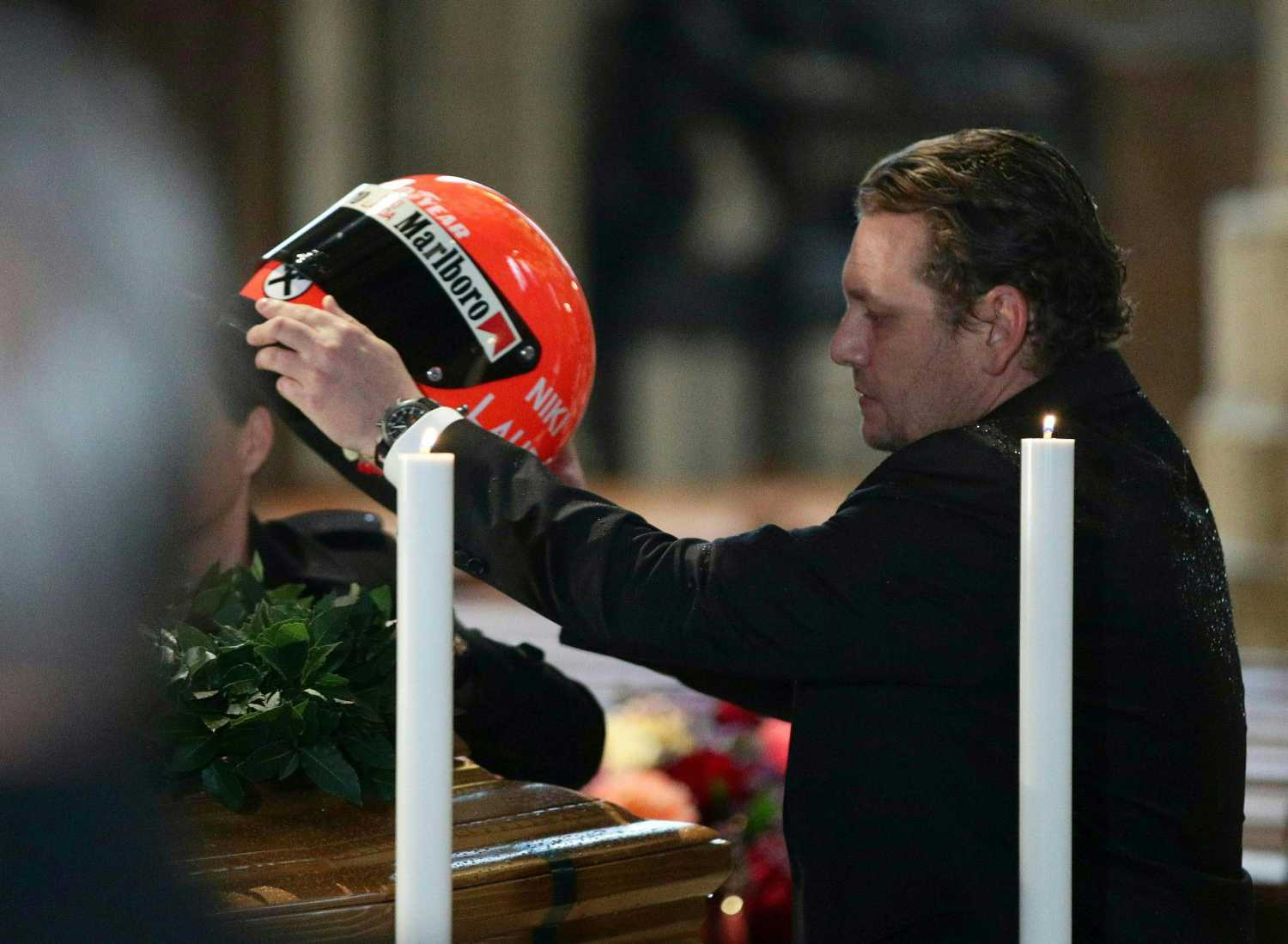 Lukas Lauda coloca el casco de su padre, Niki Lauda, en el funeral celebrado en la catedral de San Esteban en Viena