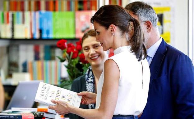 La Reina, con un libro en una de las casetas de la feria.