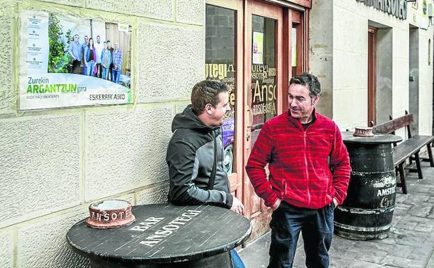 Dos vecinos charlan ante el bar Ansotegi. 