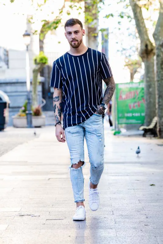 Adrían Colmenero está convencido de que “tu vestimenta dice mucho de ti”. Este joven productor y DJ tiene cerca de 30 tatuajes y combina una camiseta de Zara con zapatillas Lacoste, pulsera de Tommy Hilfiger y reloj de la firma Sekonda.
