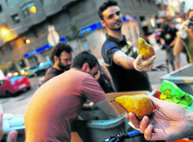 Un grupo de activistas recuperan en Madrid frutas en perfecto estado arrojadas al contenedor de la basura.