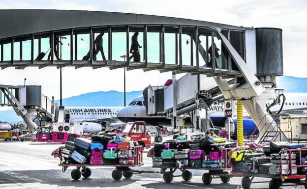 Pasajeros utilizan una de las pasarelas de Loiu para embarcar en un avión con destino a Londres