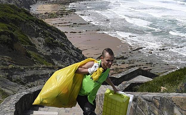 La playa es de acceso complicado, pero no ha impedido que la gente acuda a echar una mano.