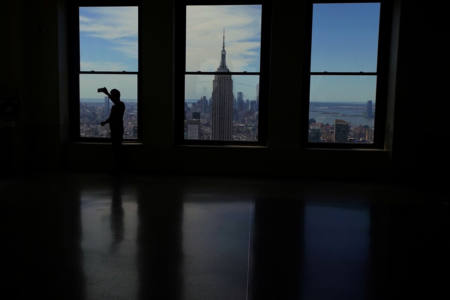 Visitantes sacando fotos del Empire State Building desde lo alto de Top of the Rock en el distrito de Manhattan, Nueva York.