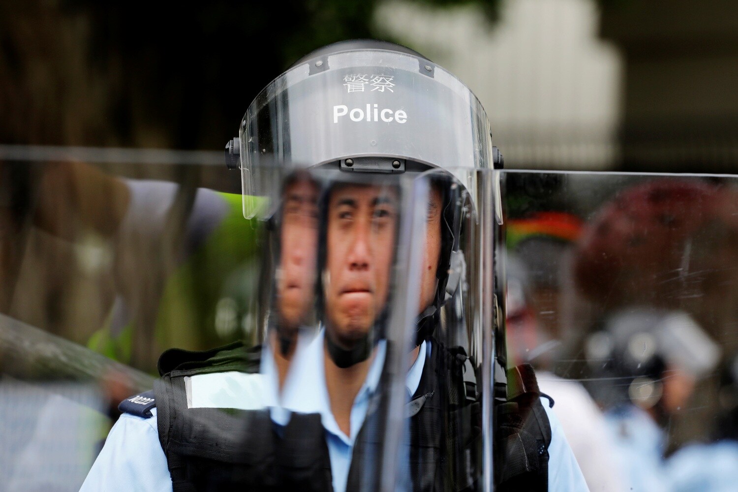 Un oficial de policía se protege tras un escudo antidisturbios durante una protesta contra el proyecto de ley de extradición en Hong Kong, China